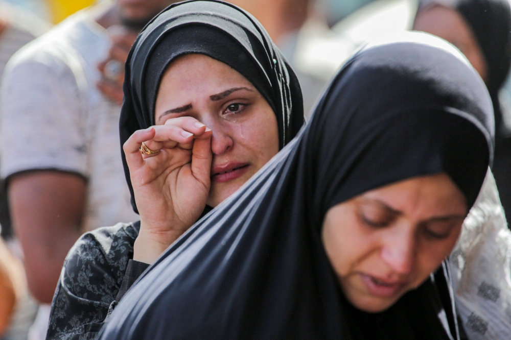 A Palestinian woman cries after identifying victims at the Al-Aqsa Martyrs Hospital in Deir al-Balah following Israeli bombardment overnight on May 23, 2024. (Photo by Bashar Taleb / AFP)