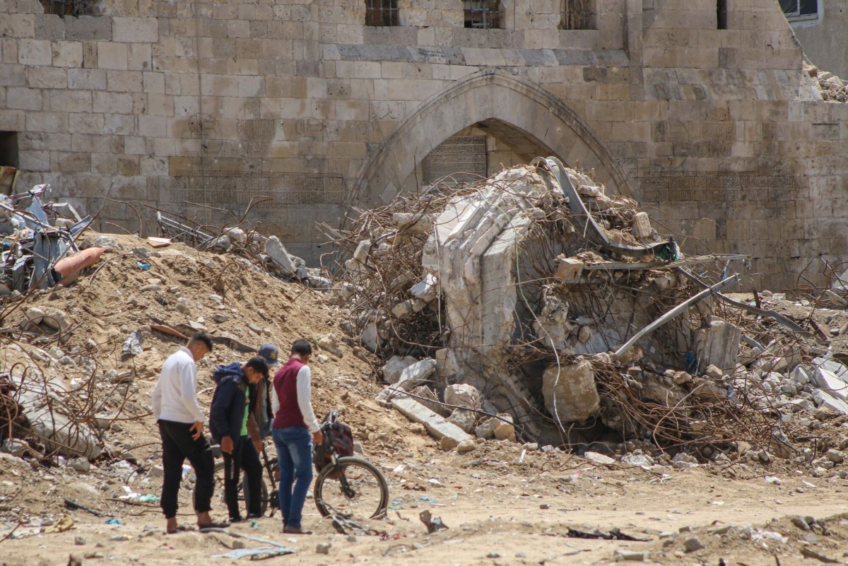 Palestinians near the ruins of destroyed buildings following the withdrawal of Israeli troops in Khan Younis, southern gaza, on April 10. MUST CREDIT: Ahmad Salem/Bloomberg
