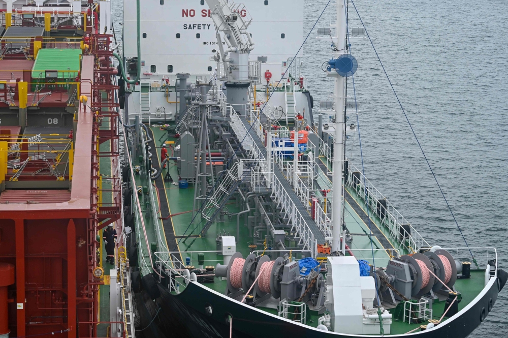 A bunkering barge (R) supplies fuel to a container ship (L) with 