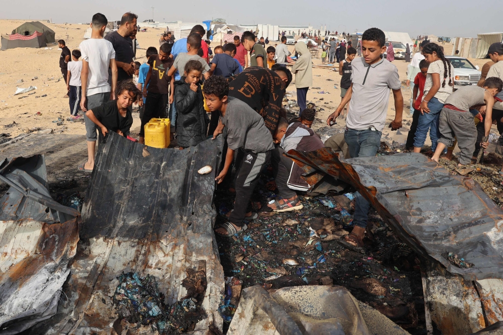 Palestinians gather at the site of an Israeli strike on a camp for internally displaced people in Rafah on May 27, 2024. (Photo by Eyad Baba / AFP)