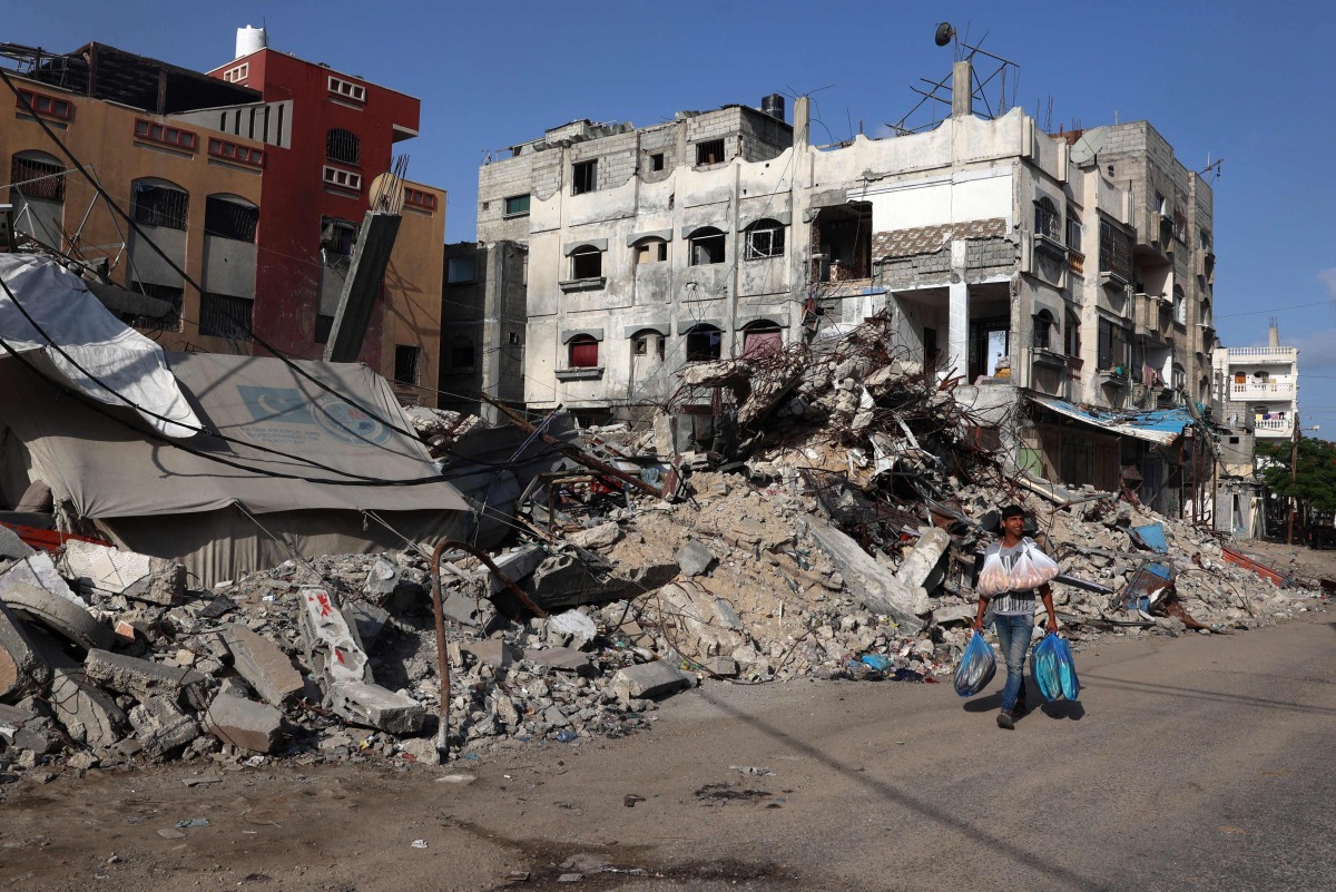 A Palestinian man walks past a destroyed building in Rafah in the southern GAZA Strip on May 26, 2024. (Photo by Eyad BABA / AFP)
