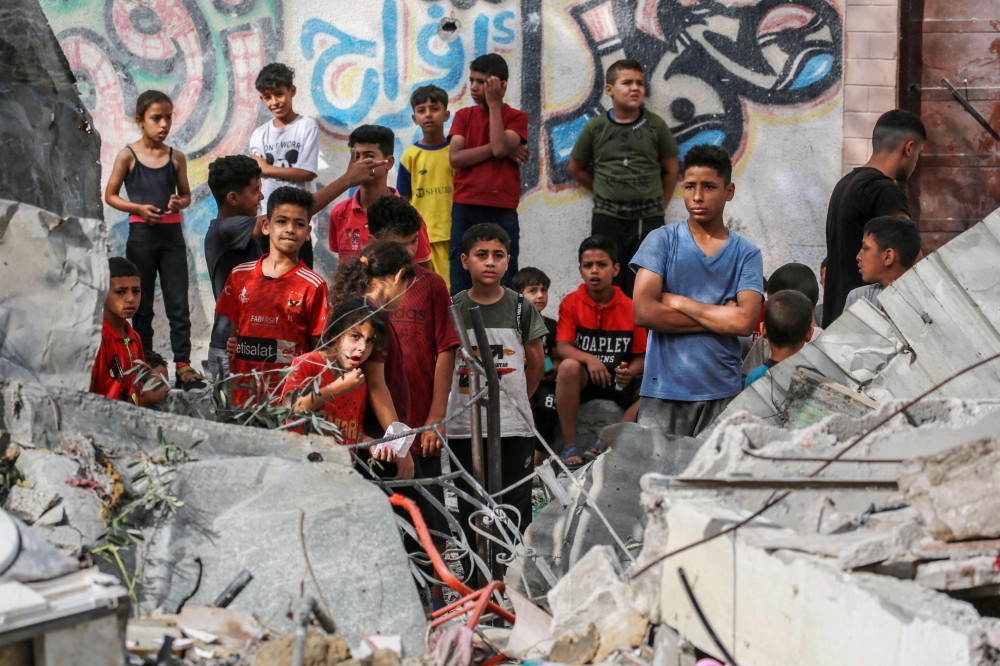 Palestinian children stand next to the rubble of the Zaqout family' house hit during overnight Israeli bombardment in Nuseirat, in the central Gaza Strip, on May 30, 2024. (Photo by Bashar Taleb / AFP)