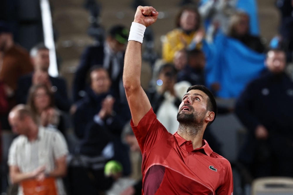 Serbia's Novak Djokovic celebrates after winning against France's Pierre-Hugues Herbert at the end of their men's singles match on Court Philippe-Chatrier on day three of the French Open tennis tournament at the Roland Garros Complex in Paris on May 28, 2024. (Photo by Anne-Christine Poujoulat / AFP)