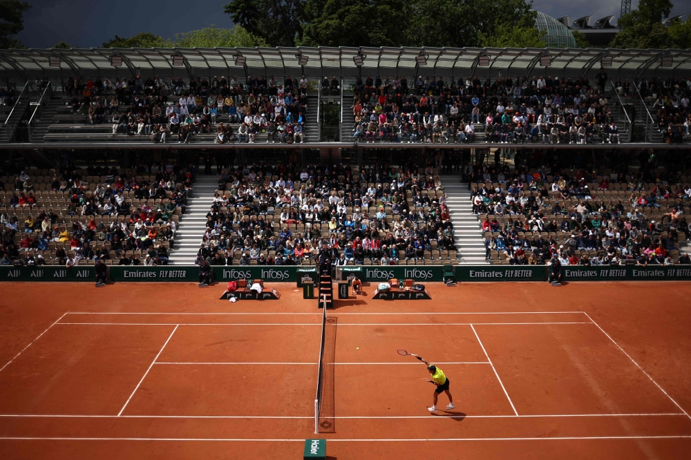 US Brandon Nakashima plays an overhead smash on Court Simonne-Mathieu on day five of the French Open tennis tournament at the Roland Garros Complex in Paris on May 30, 2024. (Photo by Anne-Christine Poujoulat / AFP)
 