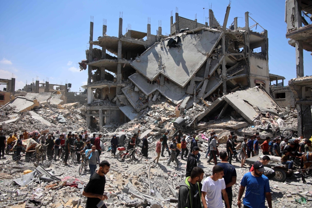 Palestinians carry some salvaged belongings as they leave the Jabalia refugee camp in the northern Gaza Strip after they returned briefly to check on their homes on May 30, 2024. Photo by Omar AL-QATTAA / AFP.