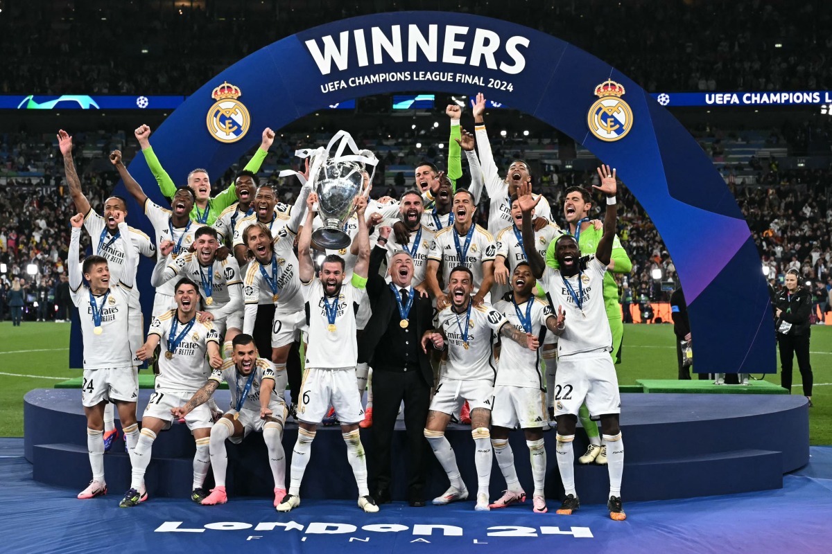 Real Madrid's Nacho Fernandez lifts the trophy to celebrate their victory at the end of the UEFA Champions League final. (Photo by Paul Ellis / AFP)