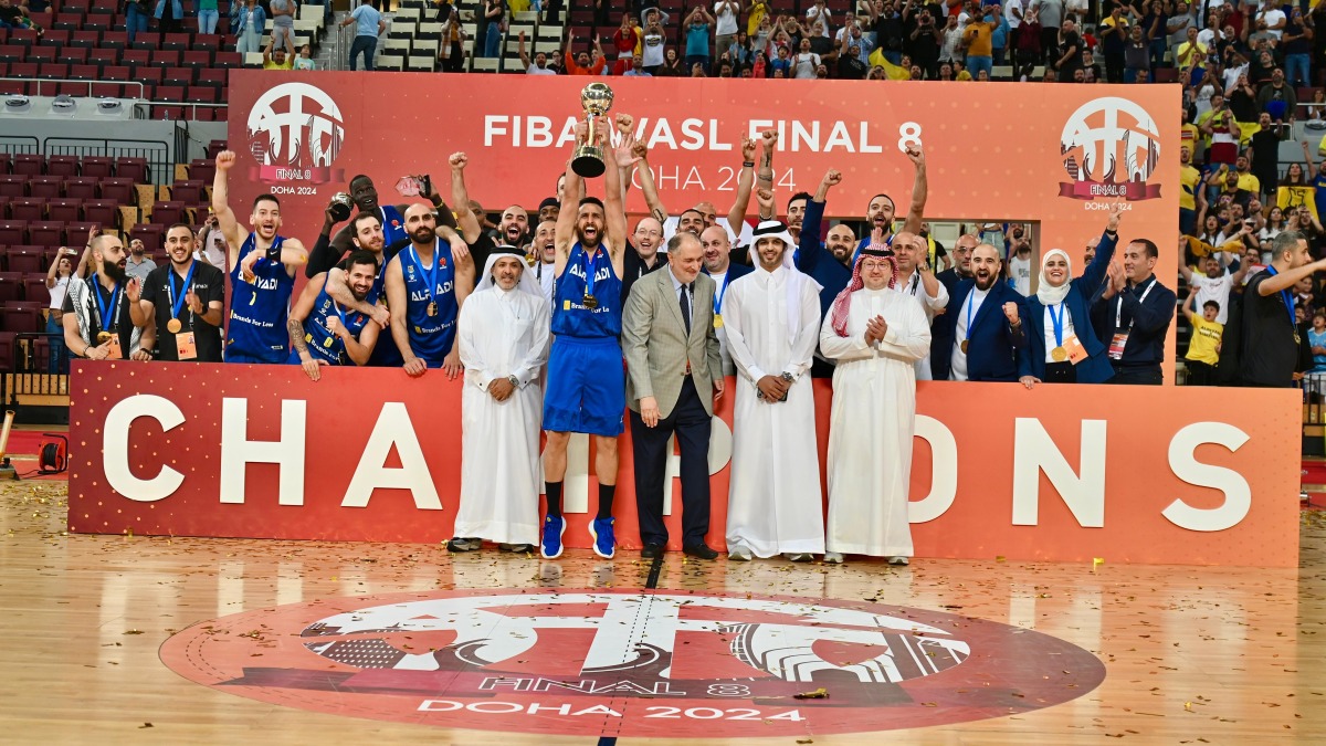 Al Riyadi players celebrate with the FIBA West Asia Super League Final 8 trophy after defeating Sagesse in the final played at the Lusail Multipurpose Hall, yesterday. 