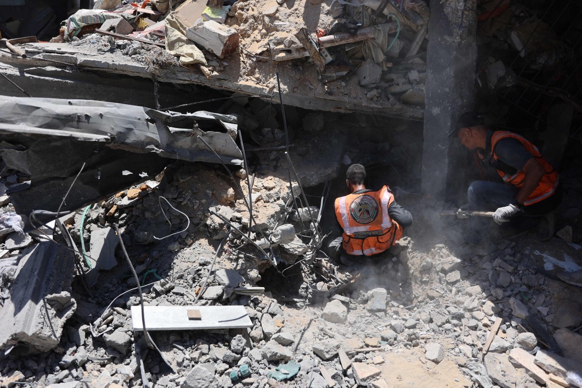 Members of the Palestinian civil defence search through the rubble of a building after it was hit in an Israeli strike in the Jabalia refugee camp in the northern gaza on June 1, 2024. (Photo by Omar AL-QATTAA / AFP)
