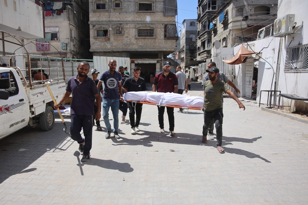 Palestinians carry the body of a Gazan killed in an Israeli strike in the Jabalia refugee camp in the northern Gaza on June 1, 2024. (Photo by Omar Al-Qattaa / AFP)