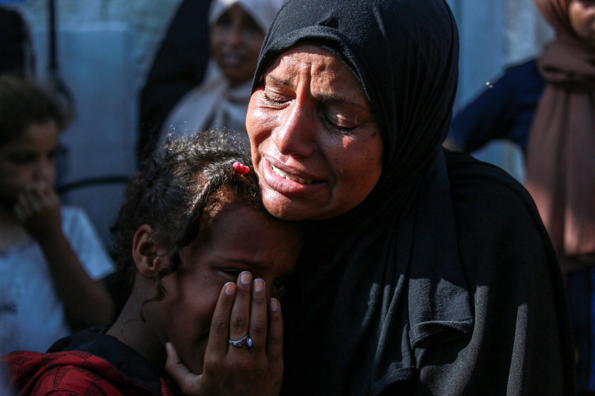 A Palestinian woman and a child cry as they mourn the death of a loved ones following Israeli bombardment, outside a hospital in Deir el-Balah in the central Gaza Strip, on June 7, 2024. (Photo by Bashar Taleb / AFP)
