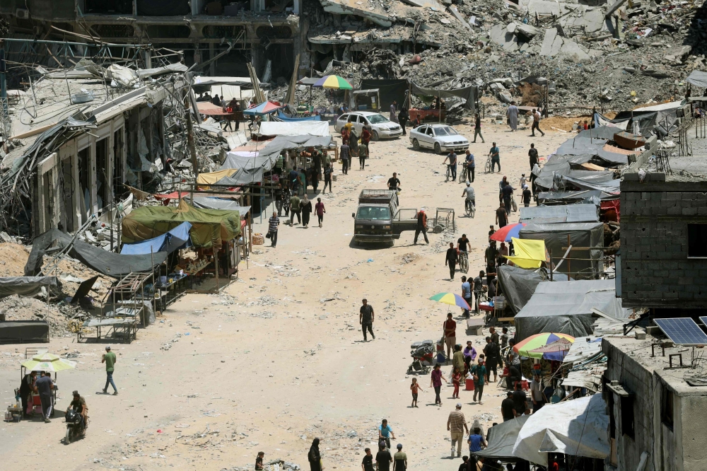 Stalls set-up by vendors close to the ruins of destroyed buildings in the Jabalia refugee camp on June 7, 2024. (Photo by Omar Al-Qattaa / AFP)