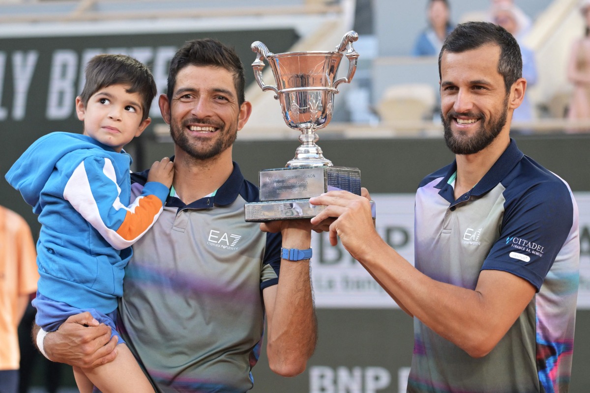 Salvador's Marcelo Arevalo (2ndL) and Croatia's Mate Pavic celebrate after winning against Italy's Simone Bolelli and Andrea Vavassori at the end of their men's doubles final match on Court Philippe-Chatrier on day fourteen of the French Open tennis tournament at the Roland Garros Complex in Paris on June 8, 2024. (Photo by Bertrand GUAY / AFP)
