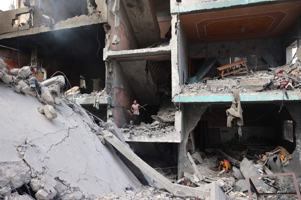 Palestinians children search through the rubble of their home a day after an operation by the Israeli Special Forces in the Nuseirat camp, in the central Gaza Strip on June 9, 2024. (Photo by Eyad Baba / AFP)
