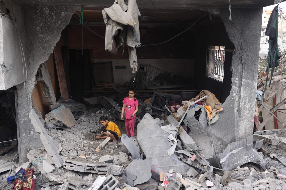 Palestinians children search through the rubble of their home a day after an operation by the Israeli Special Forces in the Nuseirat camp, in the central Gaza Strip on June 9, 2024.(Photo by Eyad Baba / AFP)