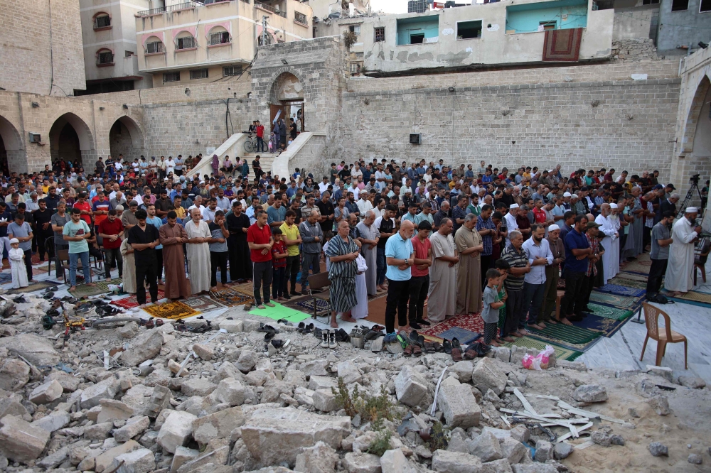 Palestinians perform the Eid al-Adha morning prayer in the courtyard of Gaza City's historic Omari Mosque on June 16, 2024. (Photo by Omar Al Qattaa / AFP)