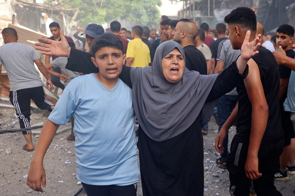 A woman reacts as people look for survivors following Israeli bombardment at al-Bureij refugee camp in the central Gaza Strip on June 16, 2024. (Photo by Eyad Baba / AFP)