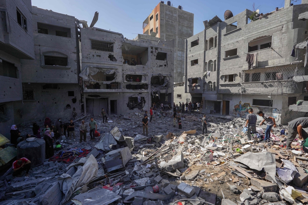 Palestinians search the rubble of the Harb family home which was hit in overnight Israeli strikes in al-Bureij refugee camp in the central Gaza Strip, on June 18, 2024. (Photo by Bashar Taleb / AFP)
 