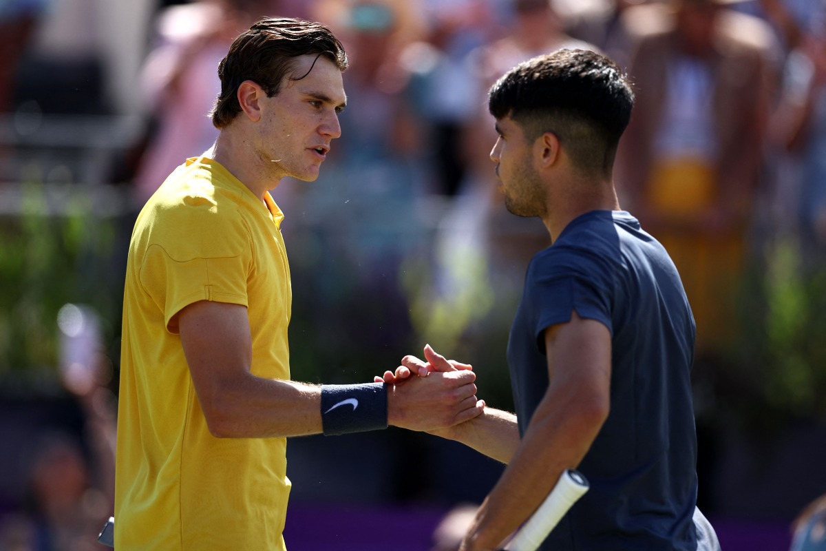 Britain's Jack Draper is congratulated by Spain's Carlos Alcaraz (R) at the end of their men's singles round of 16 match at the Cinch ATP tennis Championships at Queen's Club in west London on June 20, 2024. (Photo by HENRY NICHOLLS / AFP)