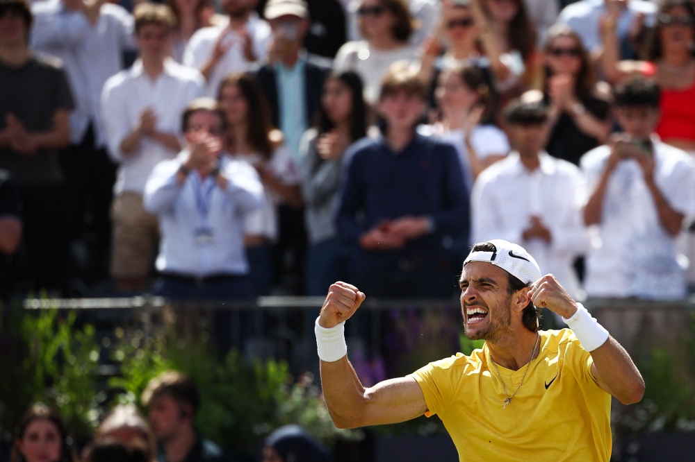 Italy's Lorenzo Musetti celebrates after winning against Australia's Jordan Thompson during their men's singles semi-finals tennis match at the Cinch ATP tennis Championships at Queen's Club in west London on June 22, 2024. (Photo by HENRY NICHOLLS / AFP)
