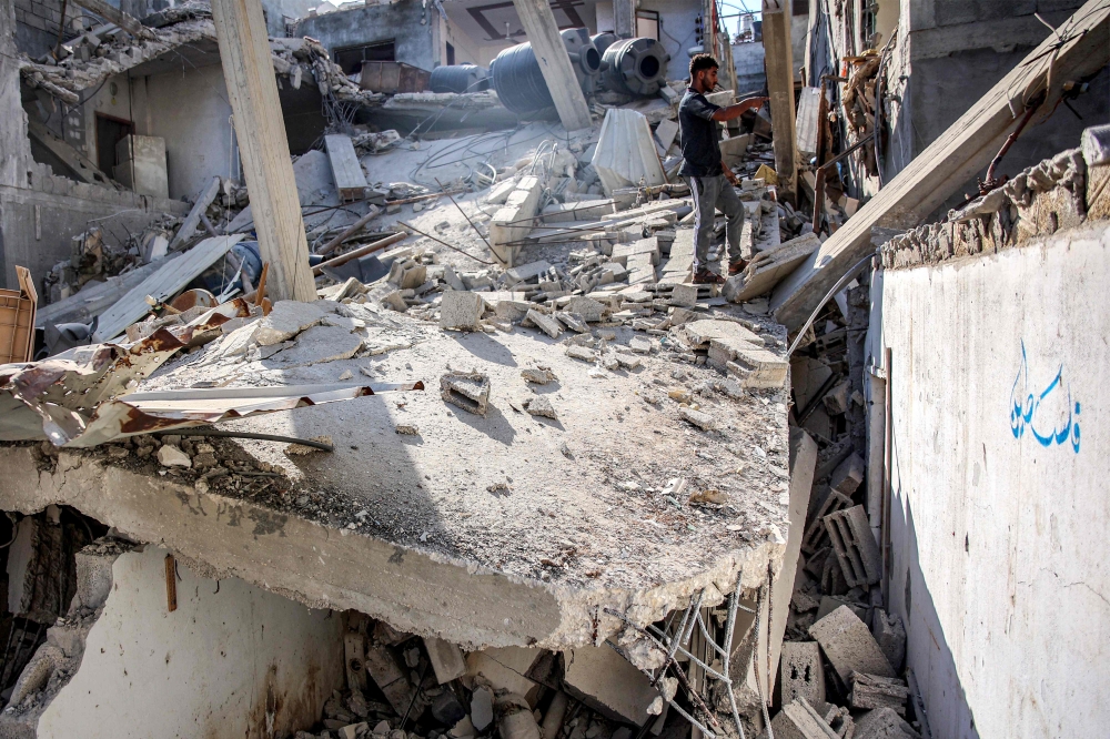 A man stands in the rubble of the house of the sister of Ismail Haniyeh, after it was hit by Israeli bombardment in the Shati camp for Palestinian refugees west of Gaza City on June 25, 2024. (Photo by Omar Al-Qattaa / AFP)