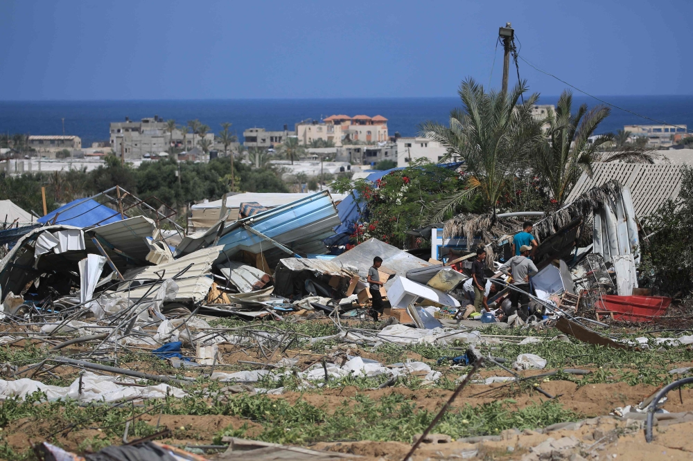 People look for salvageable items following an Israeli raid on June 29, 2024. (Photo by Eyad Baba / AFP)