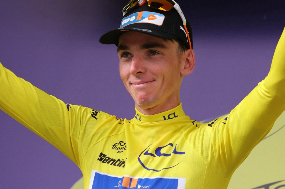 Team DSM-Firmenich PostNL team's French rider Romain Bardet celebrates on the podium with the overall leader's yellow jersey after the 1st stage of the 111th edition of the Tour de France cycling race, 206 km between Florence and Rimini, in Italy, on June 29, 2024. (Photo by Thomas SAMSON / AFP)
