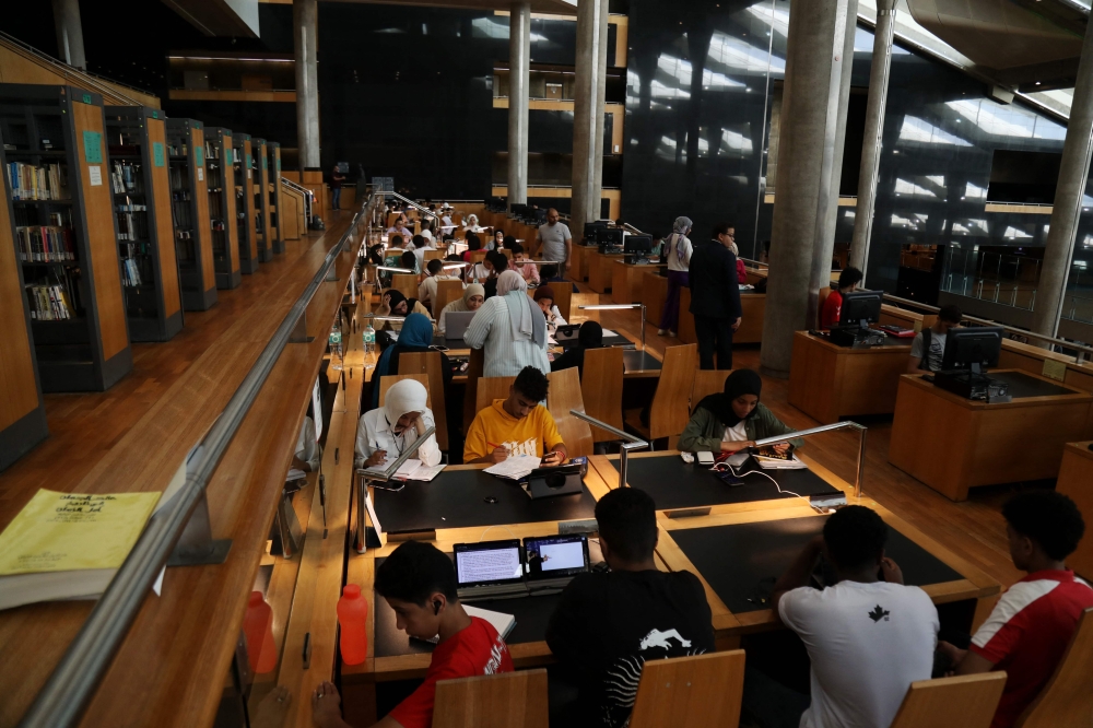 A picture taken on June 28, 2024 in the Mediterranean city of Alexandria, shows Egyptian high school students keeping cool by studying in the Alexandria Library, as Egypt began implementing planned power cuts. (Photo by Hazem Gouda / AFP)