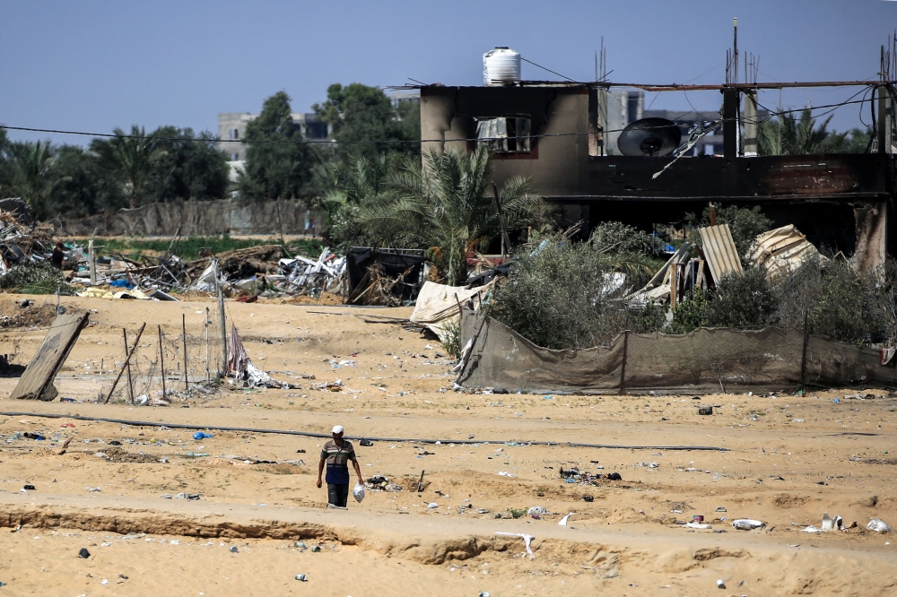 A man walks near a building damaged during Israeli bombardment in Rafah, on the southern Gaza Strip on June 29, 2024. (Photo by Eyad Baba / AFP)