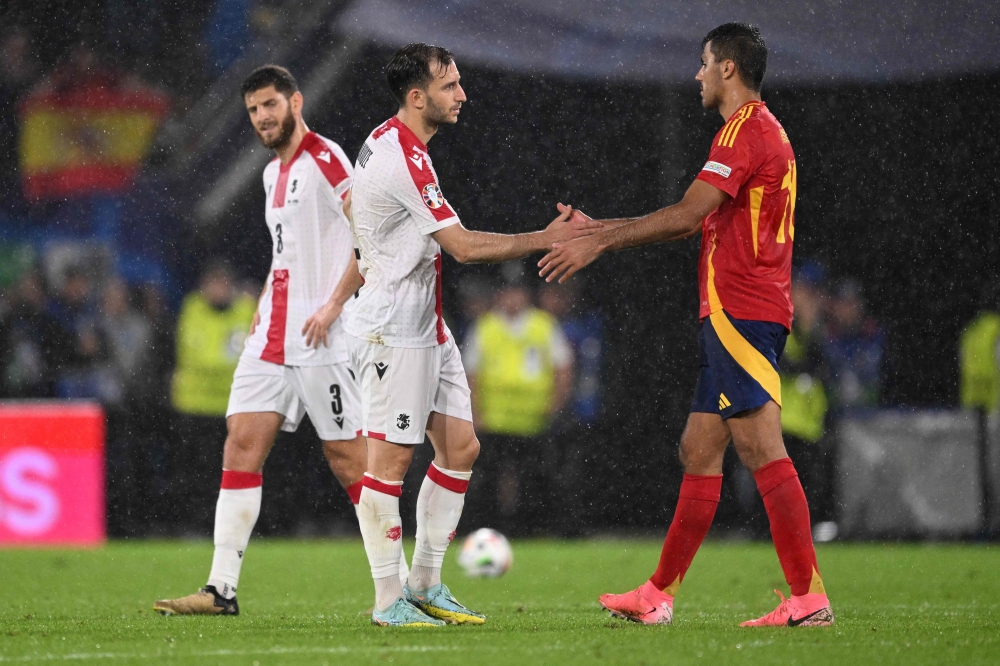 Spain's midfielder #16 Rodri and Georgia's defender #02 Otar Kakabadze greet each other at the end of the UEFA Euro 2024 round of 16 football match between Spain and Georgia at the Cologne Stadium in Cologne on June 30, 2024. (Photo by Kirill KUDRYAVTSEV / AFP)
