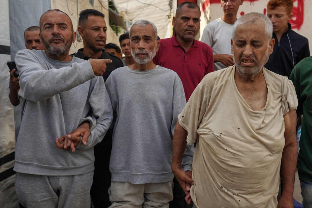 Palestinian men who had been detained by Israeli forces arrive after their release for a check-up at the Al-Aqsa Martyrs Hospital in Deir al-Balah on July 1, 2024. (Photo by Bashar Taleb / AFP)