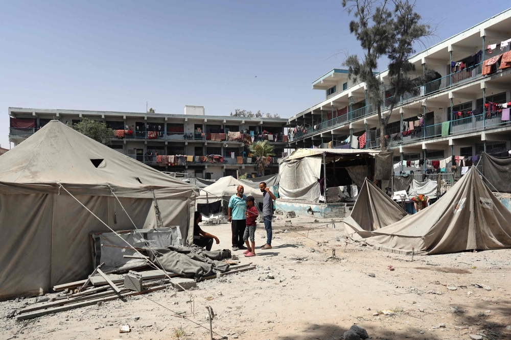 Palestinians stand near damaged tents after an Israeli strike in Khan Yunis in the southern Gaza Strip on July 4, 2024. (Photo by Bashar Taleb / AFP)