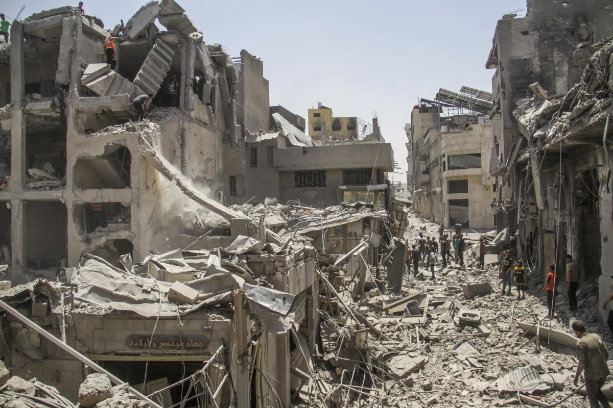  Palestinians check residential buildings destroyed by Israeli warplanes in Gaza City, July 4, 2024.(Photo by Mahmoud Zaki/Xinhua)