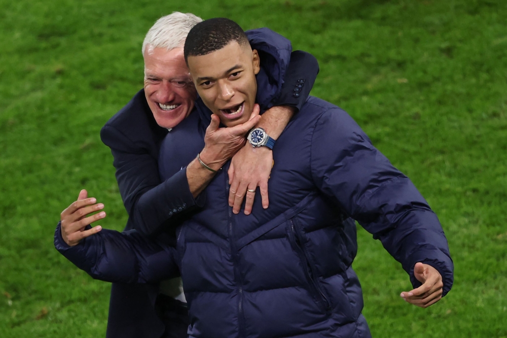 France's head coach Didier Deschamps and France's forward #10 Kylian Mbappe celebrate after winning the UEFA Euro 2024 quarter-final football match between Portugal and France at the Volksparkstadion in Hamburg on July 5, 2024. (Photo by Ronny Hartmann / AFP)