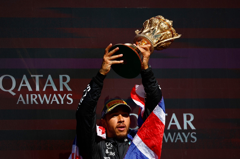 Mercedes' British driver Lewis Hamilton celebrates with the trophy on the podium after winning the Formula One British Grand Prix at the Silverstone motor racing circuit in Silverstone, central England, on July 7, 2024. (Photo by BENJAMIN CREMEL / AFP)
