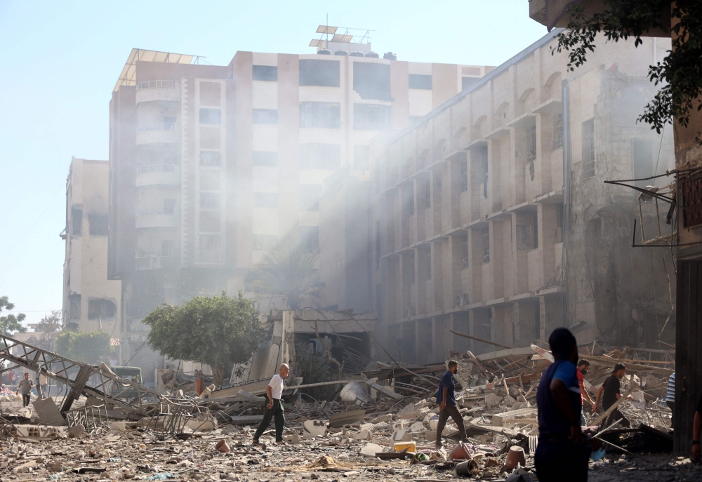 Palestinians walks on the rubble and debris of the Latin Patriarchate Holy Family School after it was hit on July 7, 2024. (Photo by Omar Al-Qattaa / AFP)