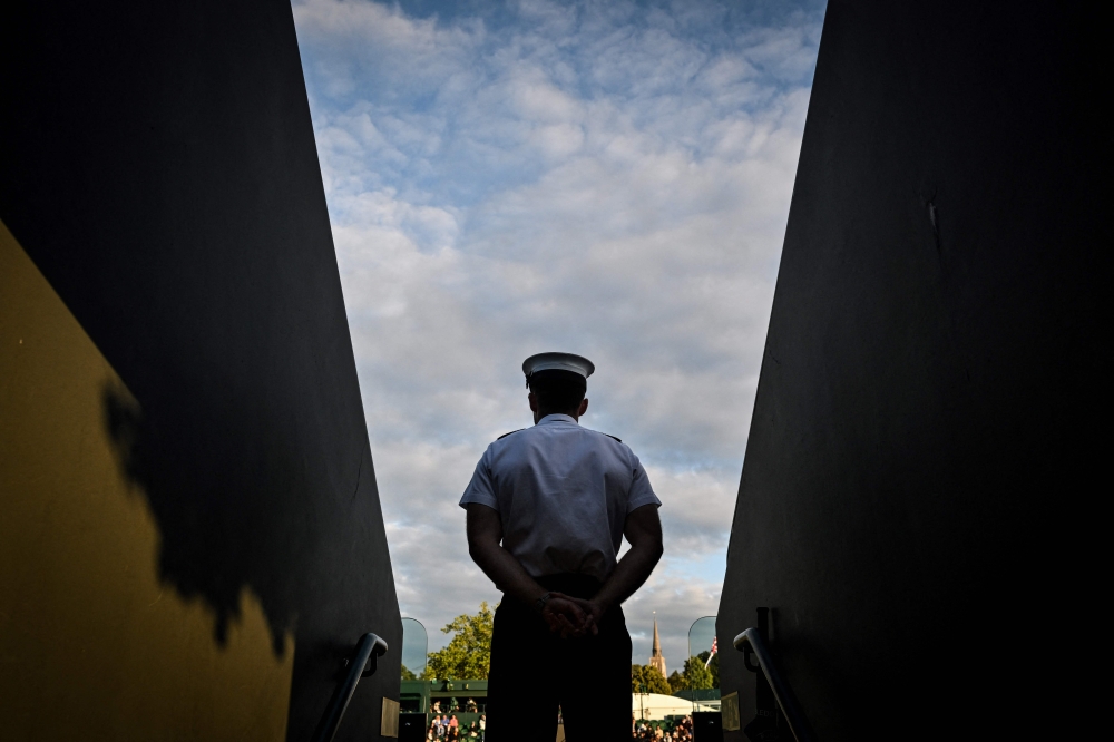 A security guard stands guard at the entrance of Court 12 on the seventh day of the 2024 wimbledon Championships at The All England Lawn Tennis and Croquet Club in Wimbledon, southwest London, on July 7, 2024. (Photo by Andrej Isakovic / AFP) 