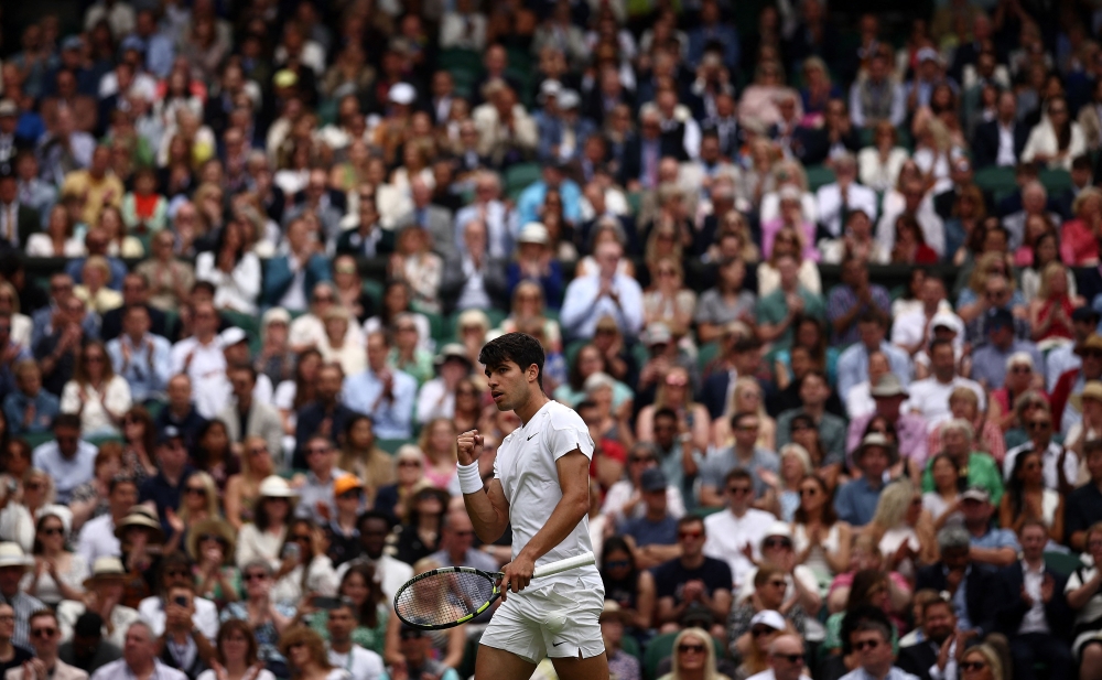 Spain's Carlos Alcaraz reacts after scoring a point against Russia's Daniil Medvedev during their men's singles semi-final tennis match on the twelfth day of the 2024 Wimbledon Championships at The All England Lawn Tennis and Croquet Club in Wimbledon, southwest London, on July 12, 2024. (Photo by HENRY NICHOLLS / AFP)