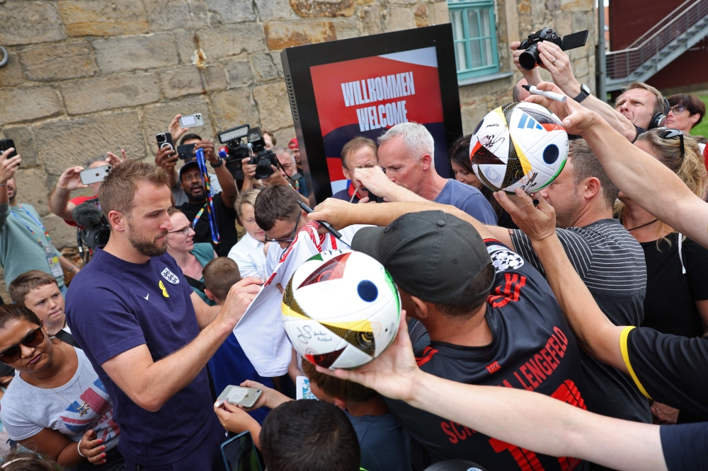 England's forward #09 Harry Kane signs autographs as he leaves the media centre on July 12, 2024. (Photo by Adrian Dennis / AFP)