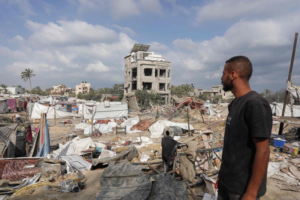 A Palestinian man looks at damaged tents at the site of Israeli bombardment a day earlier on the al-Mawasi displacement camp on July 14, 2024. (Photo by Bashar Taleb / AFP)