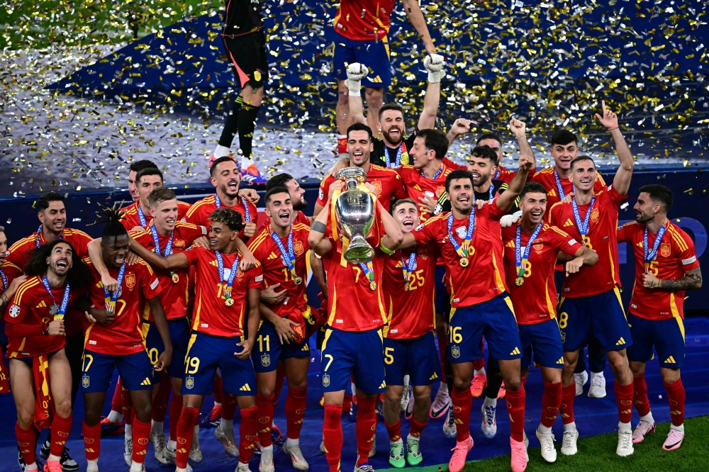 Spain's players celebrate with the trophy after winning the UEFA Euro 2024 final football match between Spain and England at the Olympiastadion in Berlin on July 14, 2024. (Photo by Tobias SCHWARZ / AFP)
