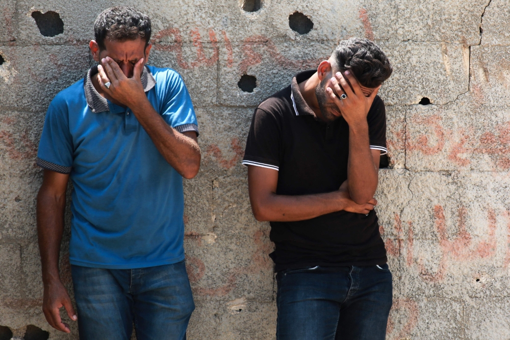 Palestinians cry during the funeral of a casualty of Israeli bombardment in Khan Yunis in the southern Gaza Strip on July 16, 2024. (Photo by Bashar Taleb / AFP)

