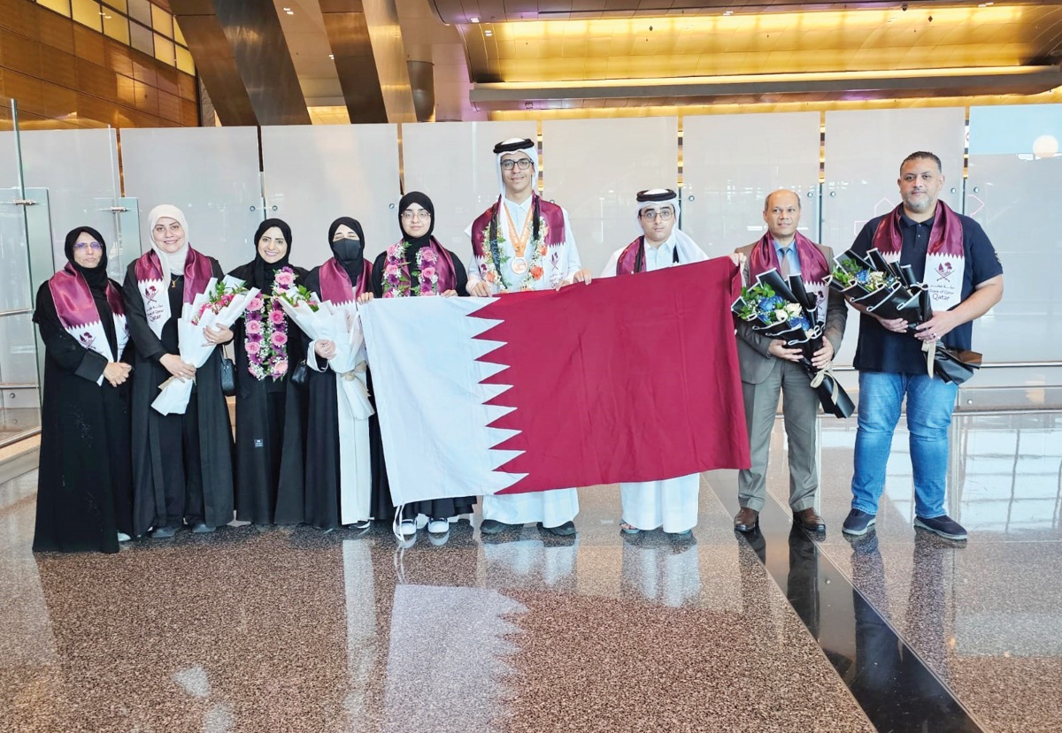 Students and officials pose with their medals upon their arrival.