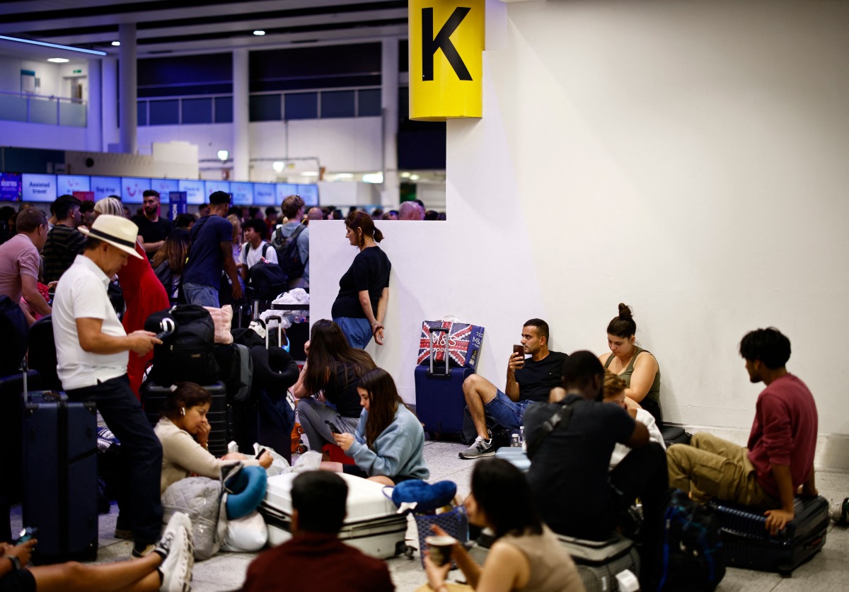 Passengers wait in the check-in area of Gatwick Airport as flights are cancelled or delayed, in Horley, south of London on July 19, 2024.  (Photo by BENJAMIN CREMEL / AFP)
