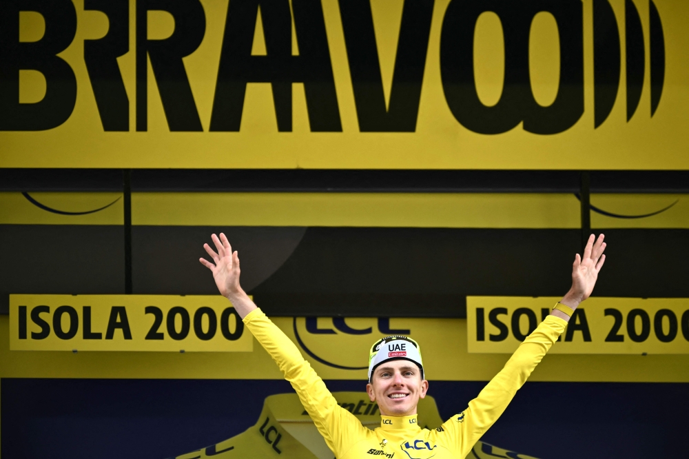 UAE Team Emirates team's Slovenian rider Tadej Pogacar celebrates on the podium with the overall leader's yellow jersey after the 19th stage of the 111th edition of the Tour de France cycling race, 144,6 km between Embrun and Isola 2000, in the French Alps, on July 19, 2024. (Photo by Marco BERTORELLO / AFP)
