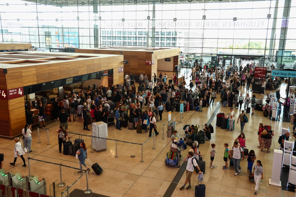 Travelers wait, following a global outage impacting computer systems at Berlin Brandenburg Airport in Berlin on Friday, July 19. (Photo: Liesa Johannssen/Bloomberg)