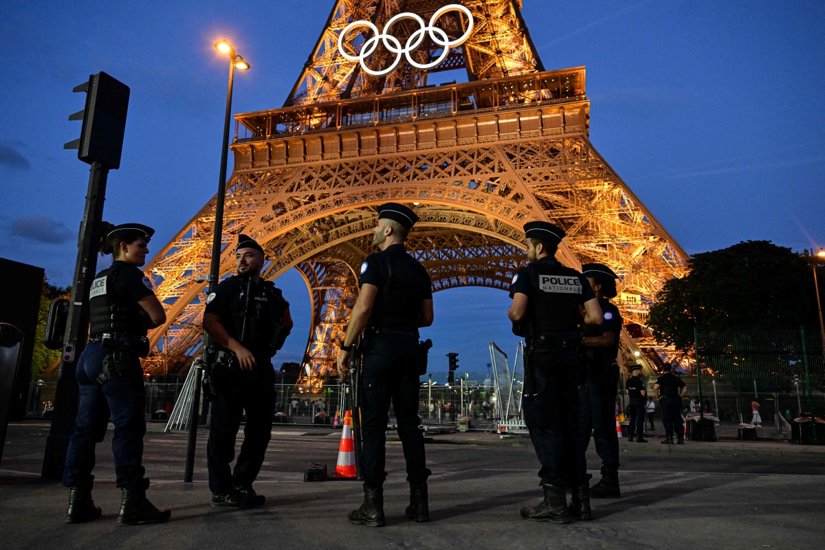 Police officers stand guard near Eiffel Tower in Paris on July 21, 2024, ahead of the Paris 2024 Olympic and Paralympic Games. (Photo by MARTIN BERNETTI / AFP)