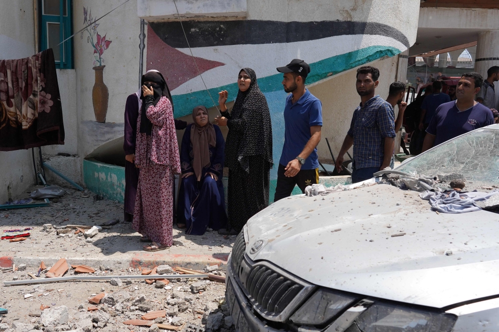 Palestinians flee from a school where they has taken refuge, after it was hit by an Israeli strike, in Deir el-Balah in the central Gaza Strip on July 27, 2024. (Photo by Bashar Taleb / AFP)
 