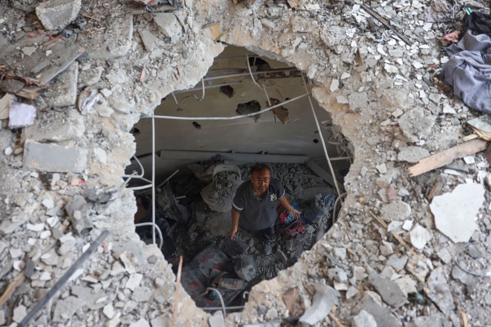 A Palestinian man inspects the damage following an Israeli strike on the Khadija school housing displaced people in Deir al-Balah, in the central Gaza Strip on July 27, 2024.(Photo by Eyad Baba / AFP)