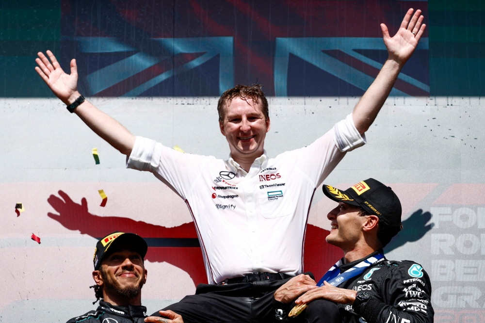 Mercedes' British driver Lewis Hamilton (L) and Mercedes' British driver George Russell (2nd R) celebrate with Mercedes' strategy manager joe Mc Millan (C) after the Formula One Belgian Grand Prix at the Spa-Francorchamps Circuit in Spa on July 28, 2024. (Photo by SIMON WOHLFAHRT / AFP)
