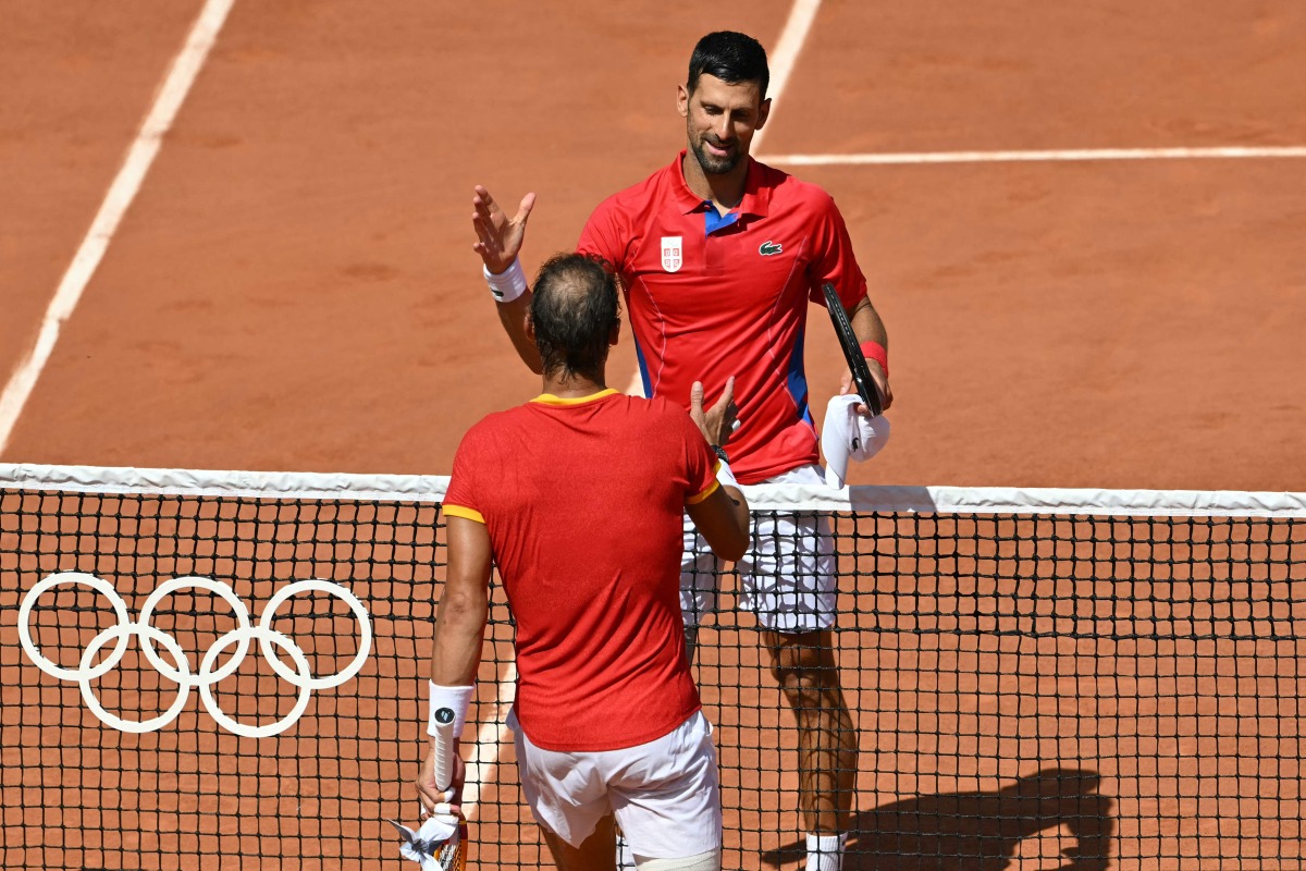 Winner, Serbia's Novak Djokovic (R) shakes hands with Spain's Rafael Nadal (L) after their men's singles second round tennis match on Court Philippe-Chatrier at the Roland-Garros Stadium at the Paris 2024 Olympic Games, in Paris on July 29, 2024. (Photo by Miguel MEDINA / AFP)
